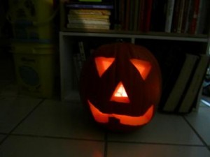 Traditional Jack o lantern with triangle eyes and nose, and a mouth with 1 tooth